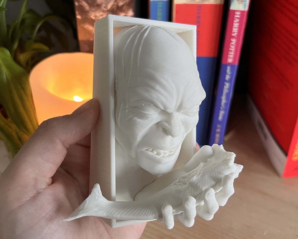 Hand holding Lord of the rings Gollum book nook for size reference against bookshelf