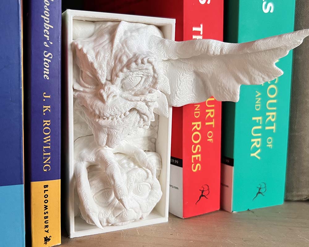 Side view of mischievous gremlin shelf insert between books