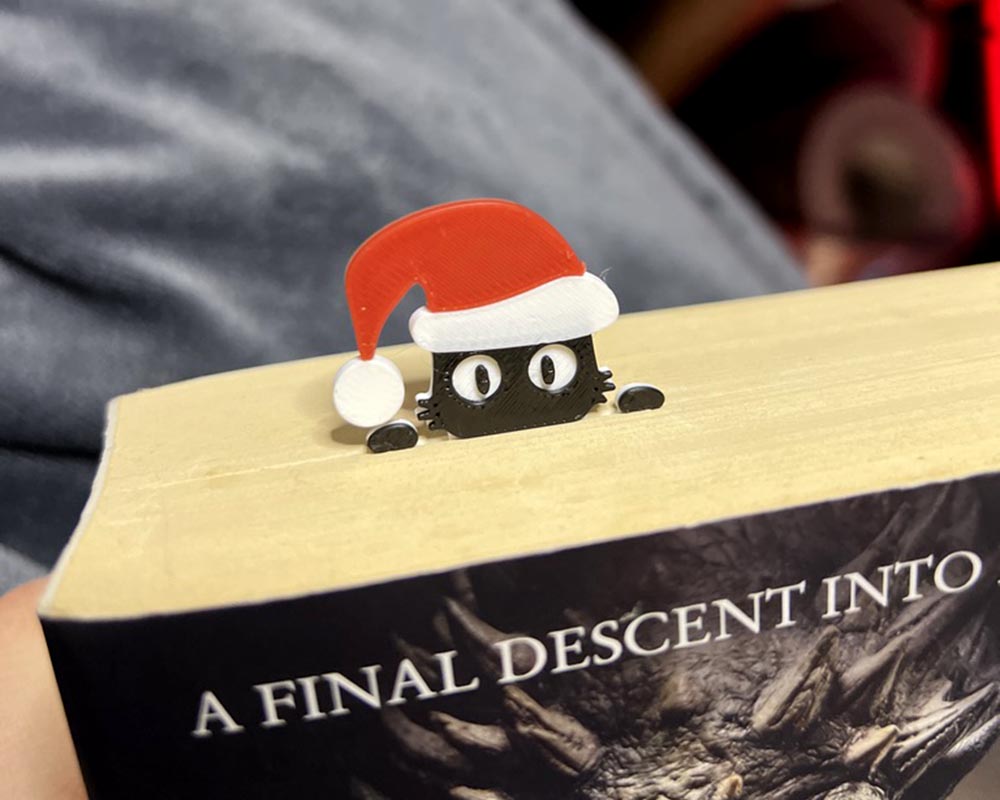 Christmas peeping cat book bookmark inside the book, cat wearing a santa hat bookmark for book lovers and cat lovers stocking fillers