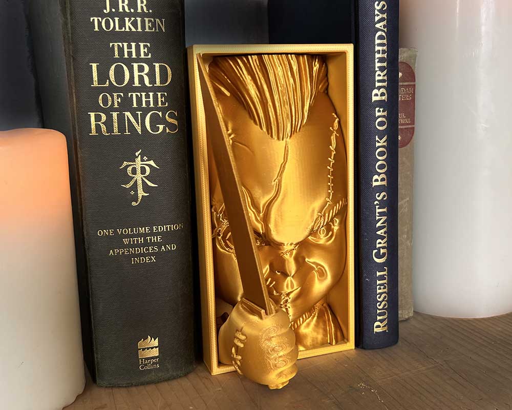 Chucky book nook with knife Child’s Play inspired 3D printed horror shelf insert featuring killer doll Creepy book nook with Chucky holding knife Handmade slasher book nook gift for Child’s Play fans Horror décor book nook insert of Chucky with grin