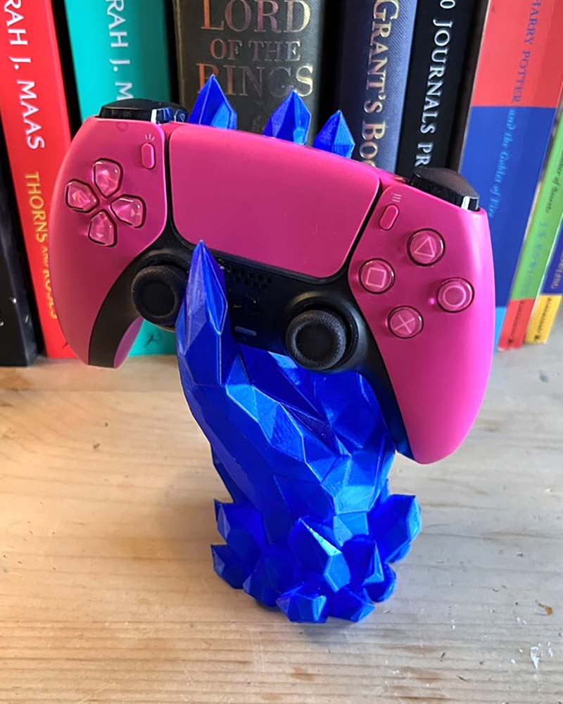 Blue geometric crystal hand for holding playstation console controller 