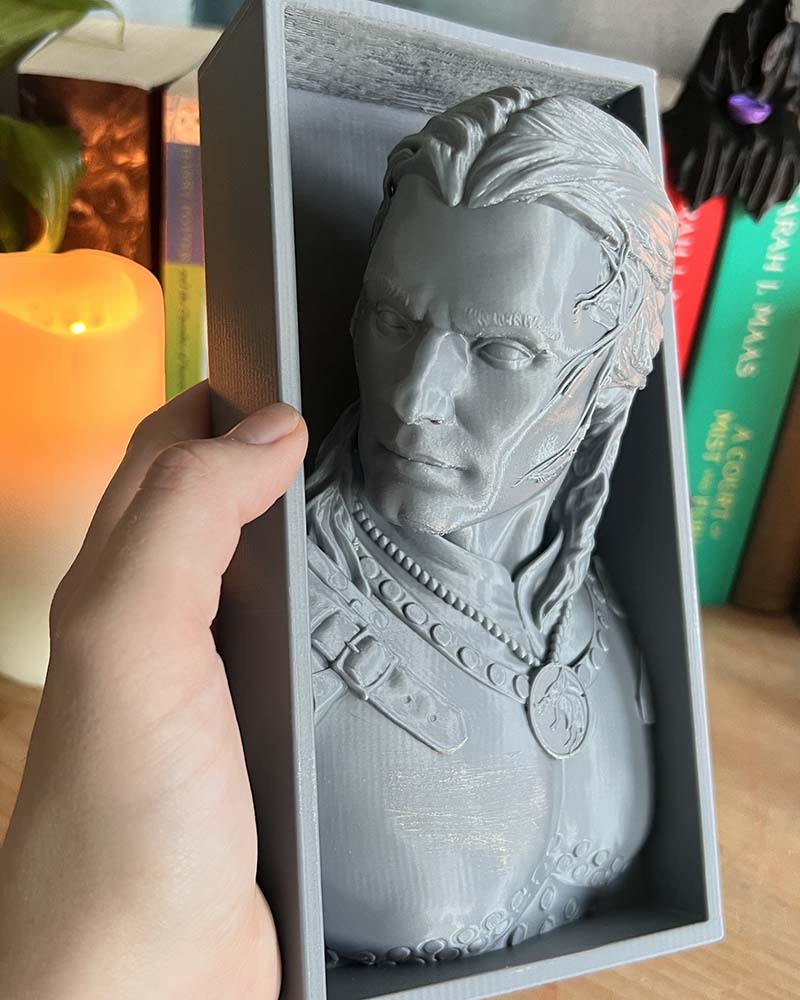Hand holding Geralt of Rivia The Witcher or White Wolf bust bookend for size reference - Henry Cavil version