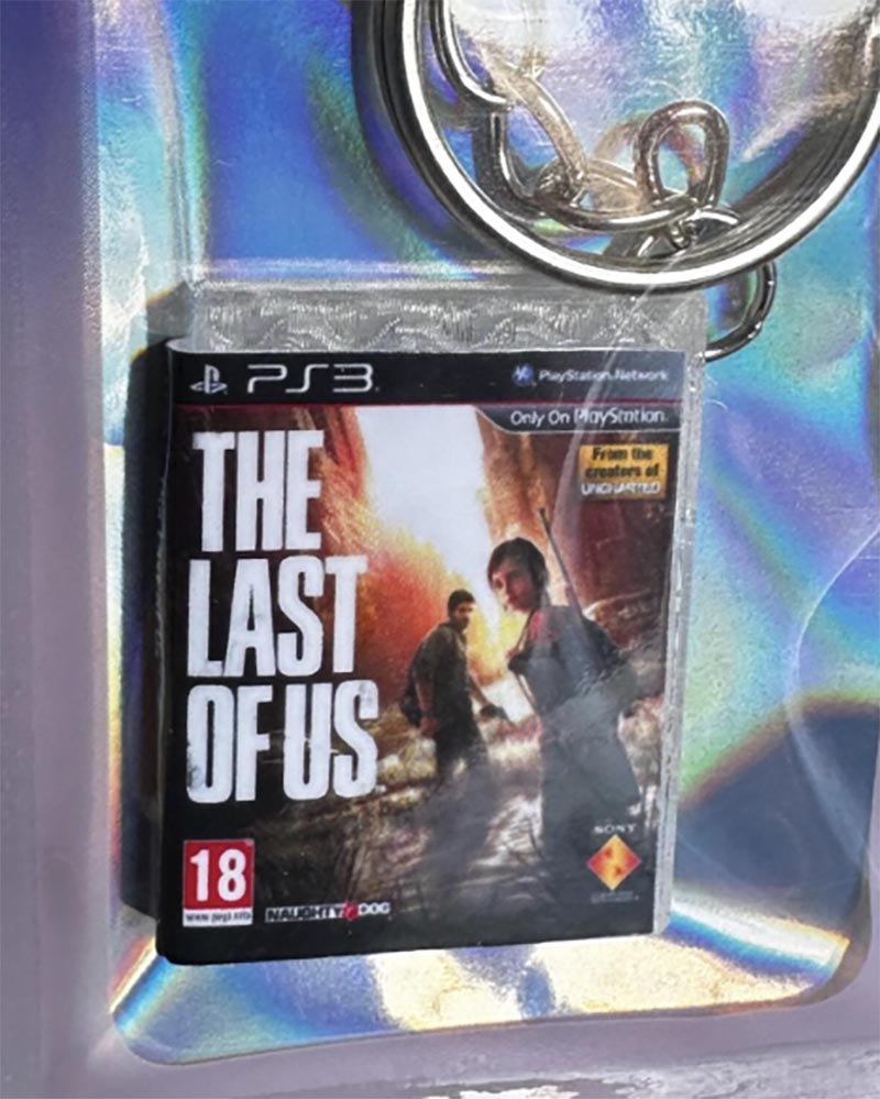 Close-up of metal keyring attached to PS3-style mini game case of the Last of Us