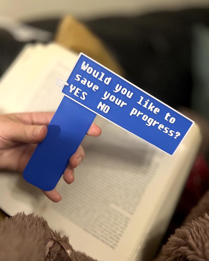 Fallout-inspired save progress bookmark in blue 3D printed gamer bookmark styled after Fallout save icon Blue save symbol book accessory for Fallout fans
