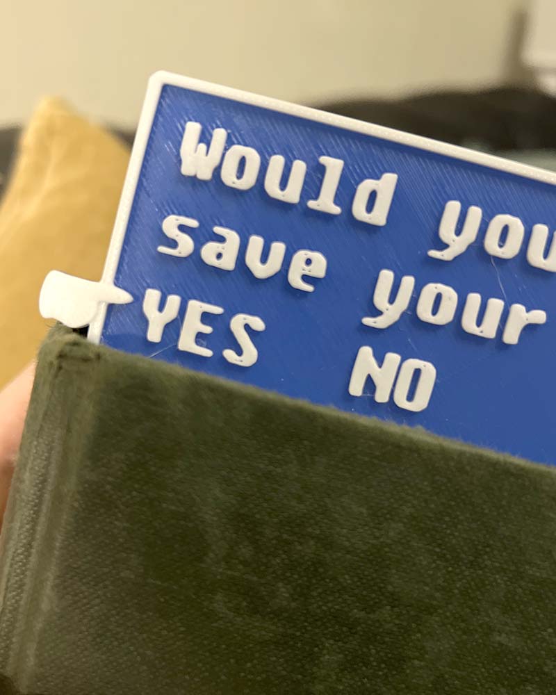 Fallout-inspired save progress bookmark in blue 3D printed gamer bookmark styled after Fallout save icon Blue save symbol book accessory for Fallout fans
close up