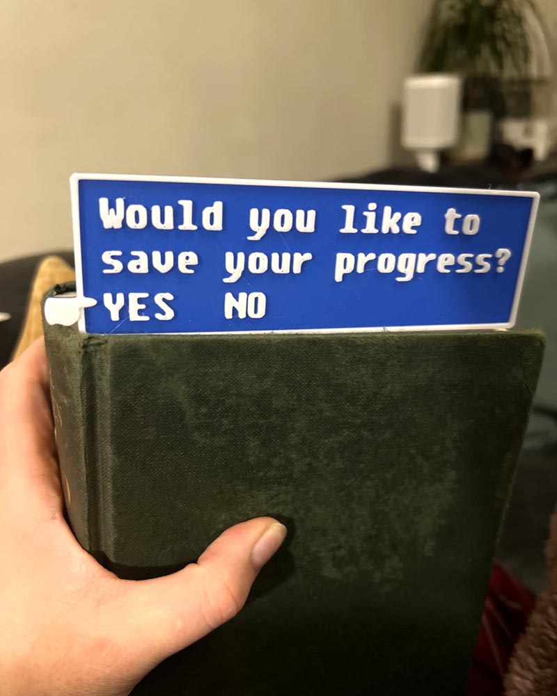 Fallout-inspired save progress bookmark in blue 3D printed gamer bookmark styled after Fallout save icon Blue save symbol book accessory for Fallout fans
