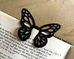 Black butterfly-shaped bookmark on an open book