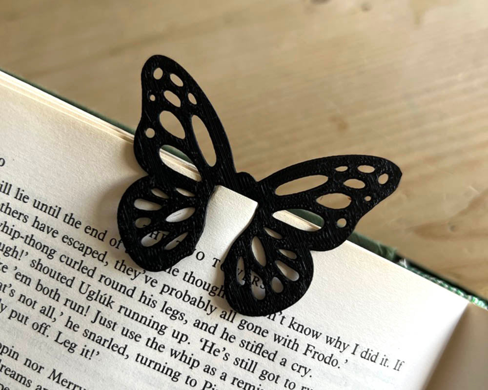 Black butterfly-shaped bookmark on an open book