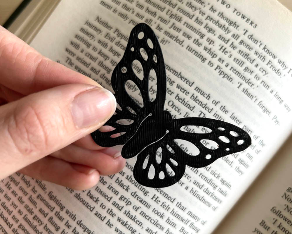 Black butterfly-shaped paper clip on an open book