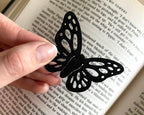 Black butterfly-shaped paper clip on an open book